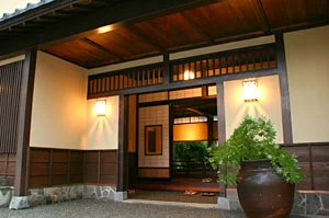 角屋旅館の正面玄関 — 夕暮れに灯る行燈と古民家の佇まい